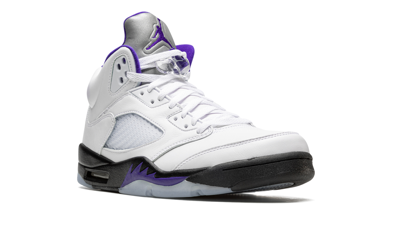 Witte en paarse Air Jordan 5 Retro schoenen met zwarte details, zichtbaar van de zijkant.
