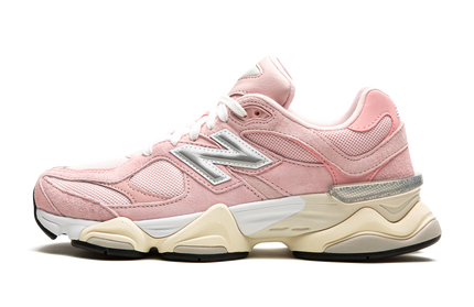 Witte en roze New Balance 9060 schoenen met roze accenten en witte zool, getoond op een witte achtergrond