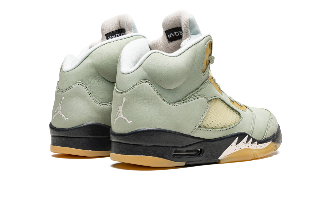 Witte en jade groene Air Jordan 5 Retro schoenen met zwart details, zichtbaar met veters en sneakerzool.