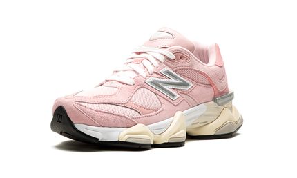 Lichte roze New Balance 9060 schoenen met wit en roze details, zichtbaar op de afbeelding.