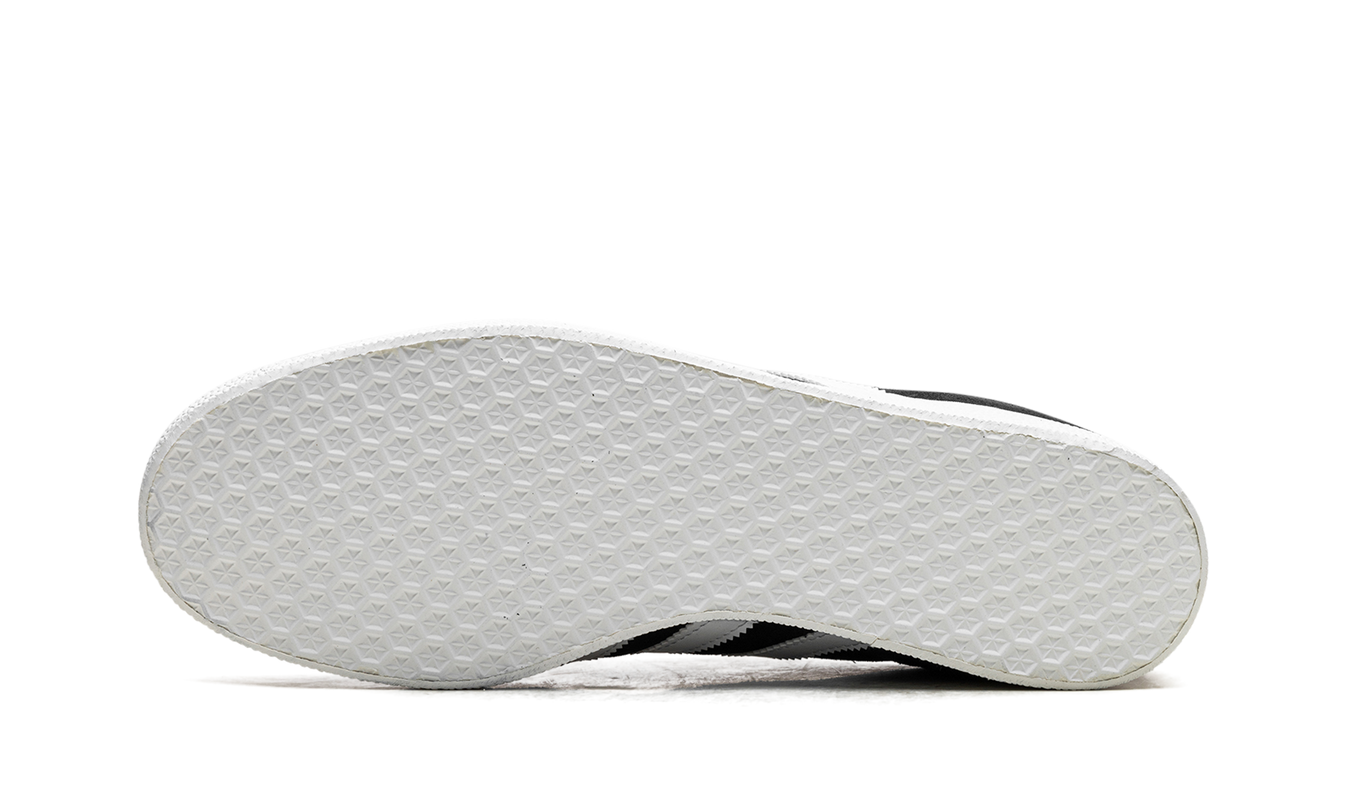 Zwarte Adidas Gazelle schoenen met witte accenten, casual sneakers voor heren en dames, op een witte achtergrond.