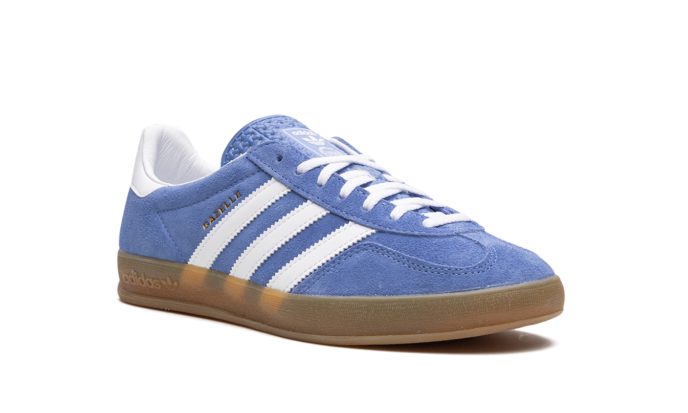 Witte en blauwe Adidas Gazelle Indoor damesschoenen met blauwe details, geschikt voor binnensporten.