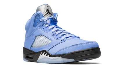 Witte en blauwe Air Jordan 5 Retro SE sneakers met kenmerkende details en merklogo, liggend op een witte achtergrond