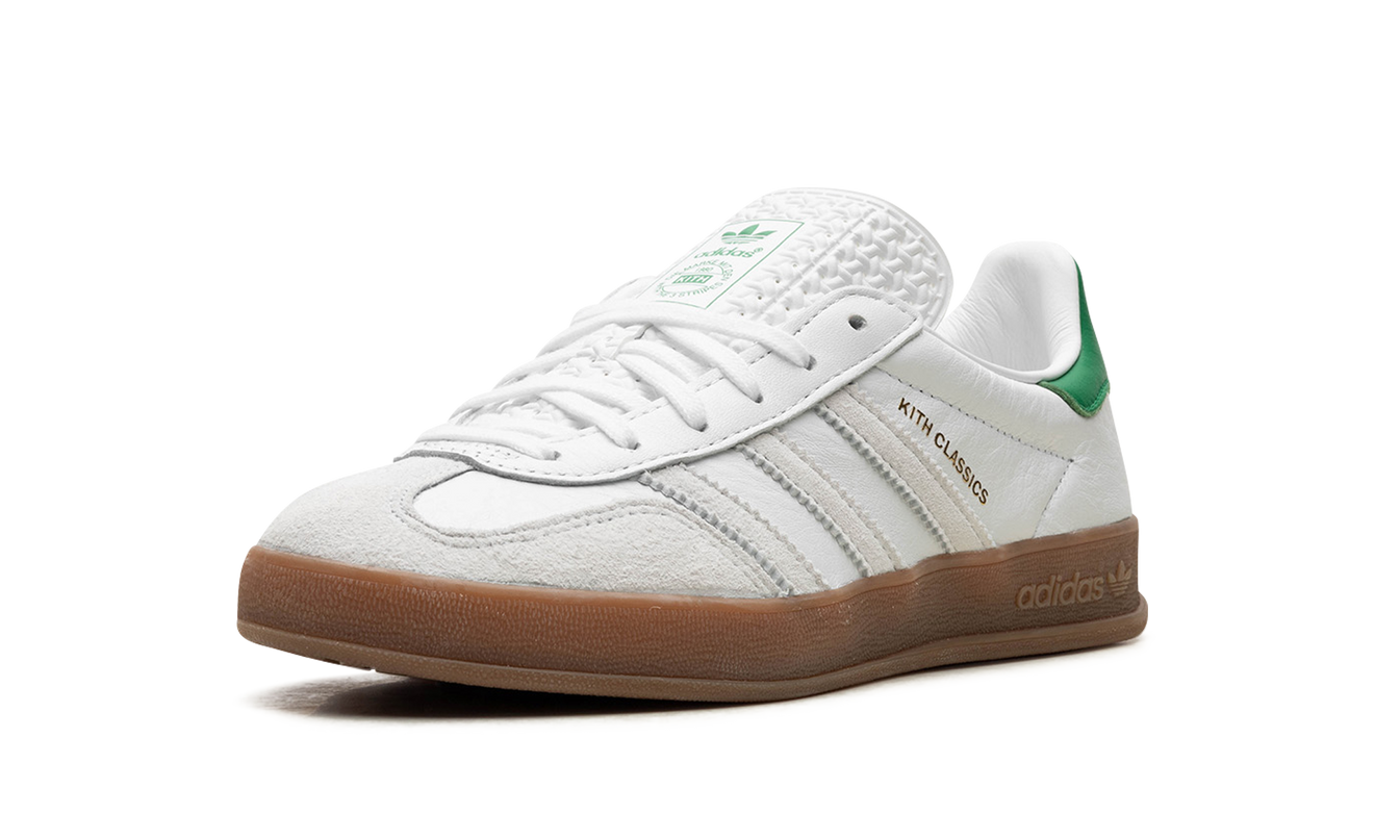 Witte en groene Adidas Gazelle indoor schoenen met Kith-ontwerp, geschikt voor binnengebruik, op een neutrale achtergrond.