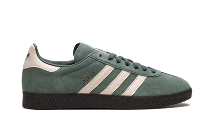 Donkerblauwe Adidas Gazelle Mexico schoenen met witte accenten en leren bovenwerk, gedragen door een model.