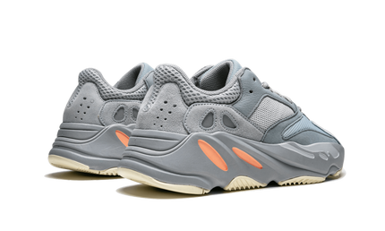 Witte en grijze Yeezy Boost 700 schoenen met gestroomlijnd ontwerp en dikke zool, zichtbaar op de afbeelding.