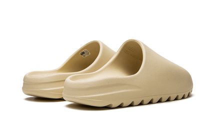 Lichte beige Yeezy Slide "Bone 2022" schoenen met gestroomlijnd ontwerp en gebogen voetbed, geschikt voor casual dragen.