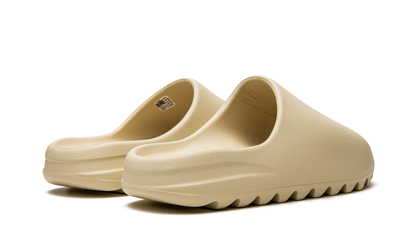 Lichte beige Yeezy Slide "Bone 2022" schoenen met gestroomlijnd ontwerp en gebogen voetbed, geschikt voor casual dragen.