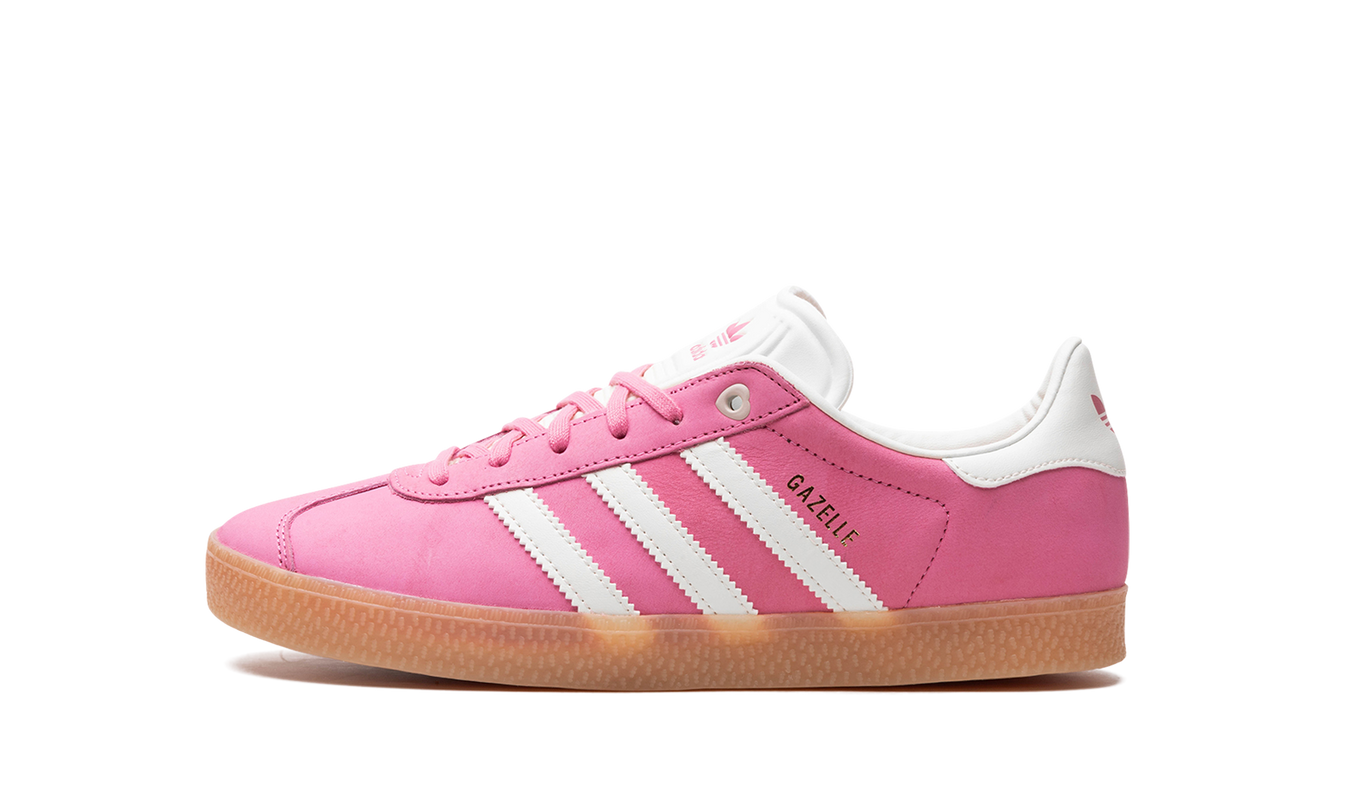 Lichte roze Adidas Gazelle GS sneakers met witte zool en zwarte details, gelegen op een neutrale achtergrond.