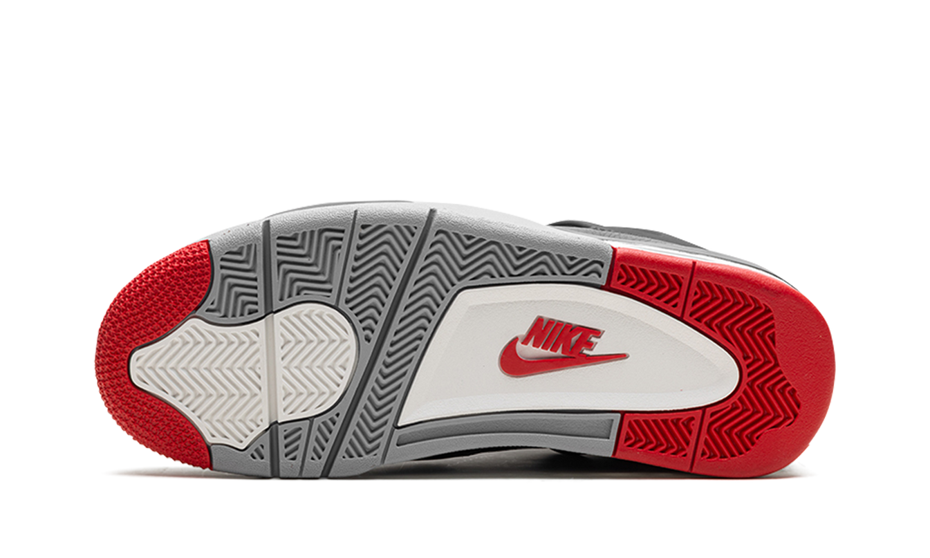 Zwarte Air Jordan 4 "Bred Reimagined" schoenen met rode accenten en witte zool, gedragen door een model.