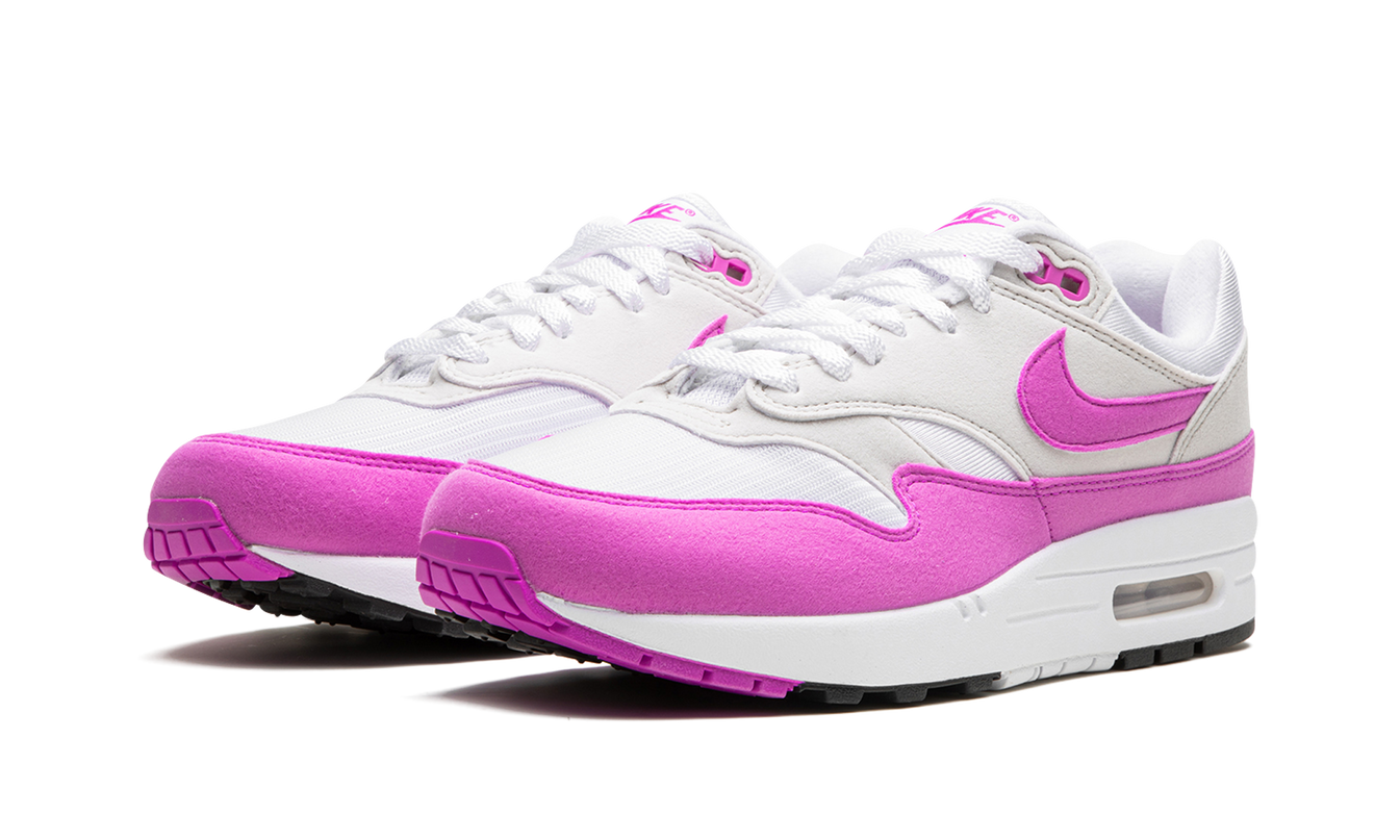 Lichte roze Nike Air Max 1 WMNS schoenen met witte details en roze accenten, zichtbaar op een witte achtergrond.