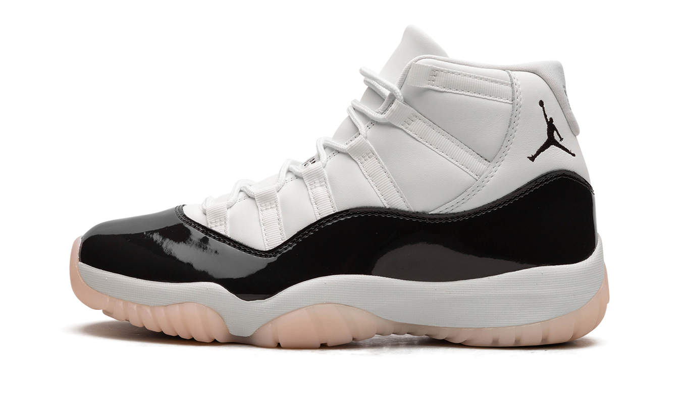 Lichte Air Jordan 11 WMNS "Neapolitan" sneakers in wit, roze en bruin met leren en suède details, gedragen door een model.