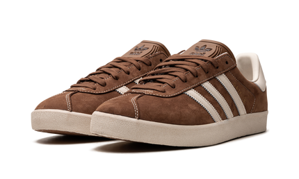 Bruine Adidas Gazelle schoenen met leren bovenwerk en witte zool, close-up van de schoenen op een neutrale achtergrond