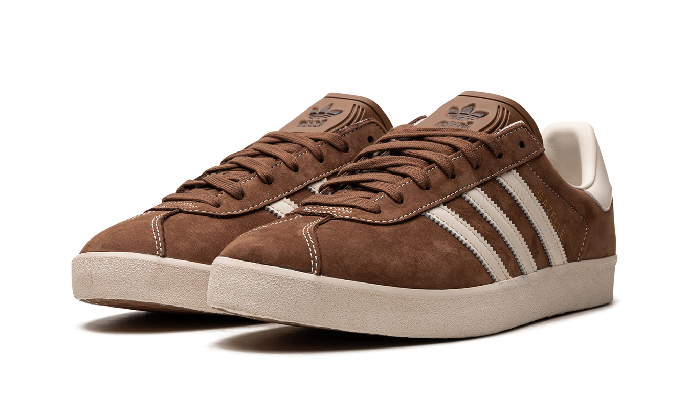 Bruine Adidas Gazelle schoenen met leren bovenwerk en witte zool, close-up van de schoenen op een neutrale achtergrond