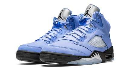 Witte en blauwe Air Jordan 5 Retro SE sneakers voor heren, met kenmerkende details en merklogo, op witte achtergrond.