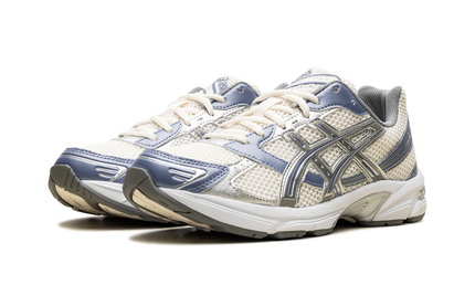 Witte en blauwe Asics Gel 1130 hardloopschoenen met beige accenten, geschikt voor sport en casual dragen.