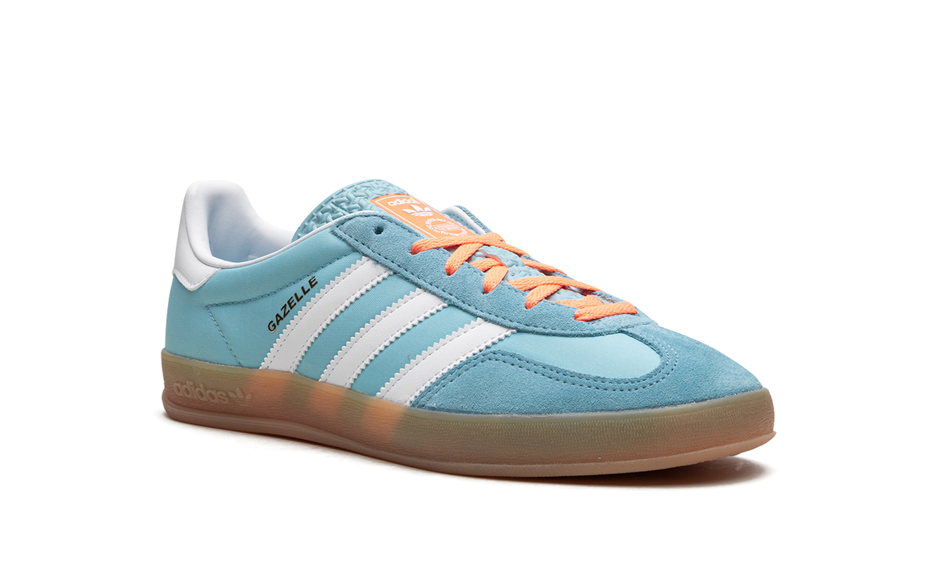 Blauwe en witte Adidas Gazelle indoor schoenen met gumzool, gedragen door een model, comfortabele sportieve schoenen.