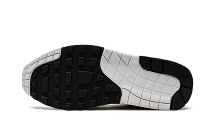 Nike Air Max 1 sneakers in zwart en rood met Hangul Day details, zichtbaar in close-up op witte achtergrond