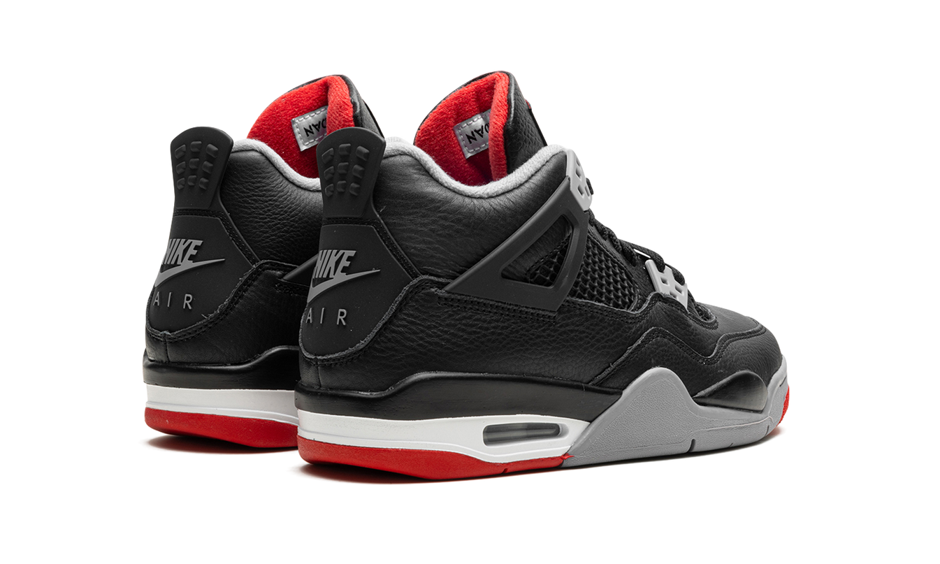 Lichte close-up van de Air Jordan 4 GS "Bred Reimagined" schoenen in zwart en rood met details van Mijn winkel.