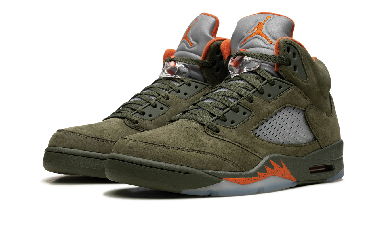 Lichte groene Air Jordan 5 OG sneakers van Mijn winkel met zwart en witte details, zichtbaar van de zijkant op een witte achtergrond.