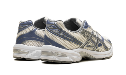 Witte en blauwe Asics Gel 1130 hardloopschoenen met cremekleuren, detailzicht van de sportieve sportschoenen