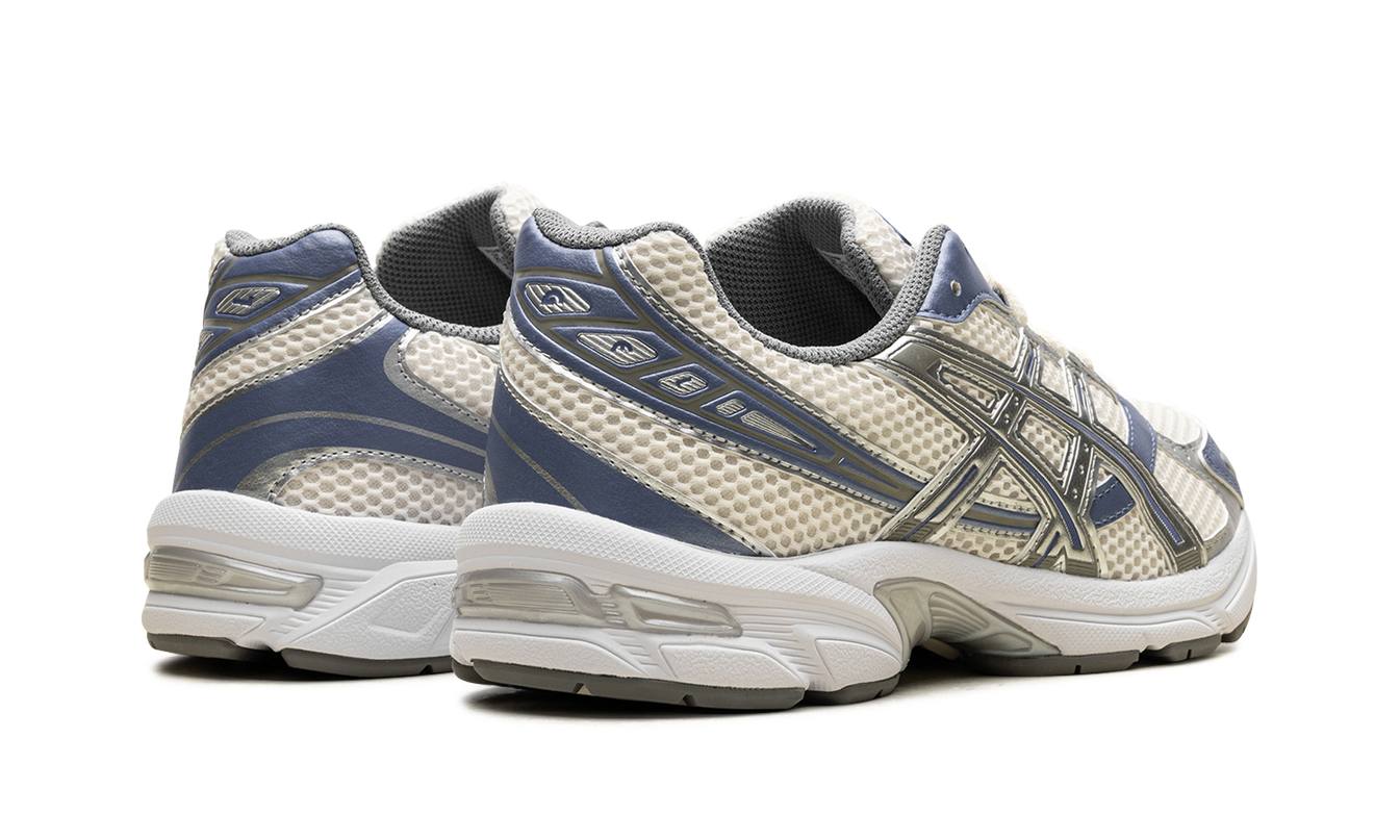 Witte en blauwe Asics Gel 1130 hardloopschoenen met cremekleuren, detailzicht van de sportieve sportschoenen