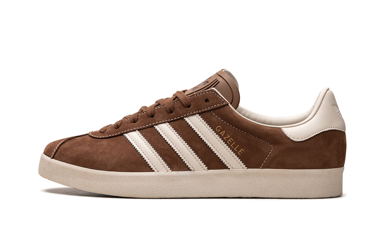 Bruine Adidas Gazelle schoenen met witte zool en merklogo, detailfoto van de sneakers op een witte achtergrond