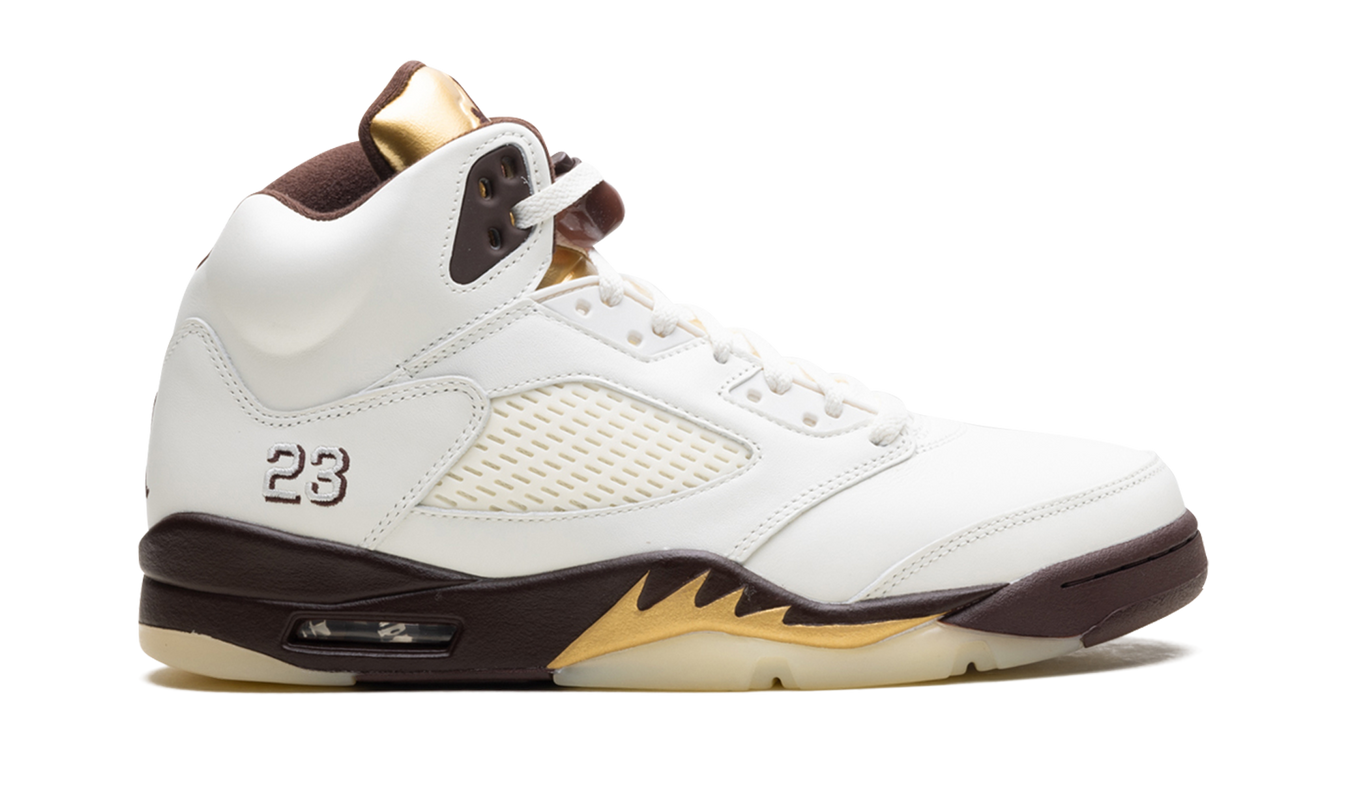 Witte Air Jordan 5 WMNS sneakers met gouden accenten en zwart details, zichtbaar in een close-up foto.