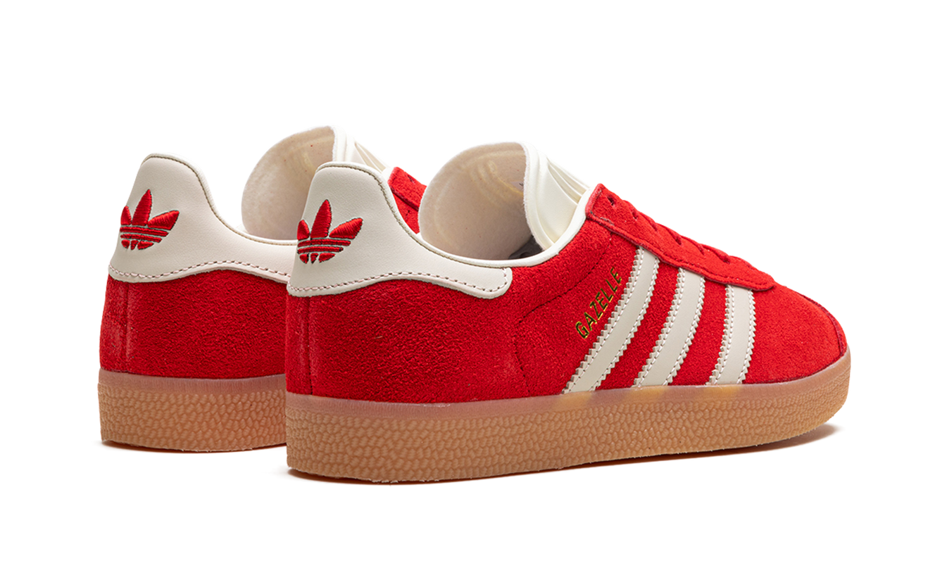 Dames Adidas Gazelle schoenen in rood, zwart en wit, zichtbaar vanaf de zijkant op een witte achtergrond