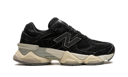 Zwarte New Balance 9060 sneakers met suède details, getoond in een close-up afbeelding.
