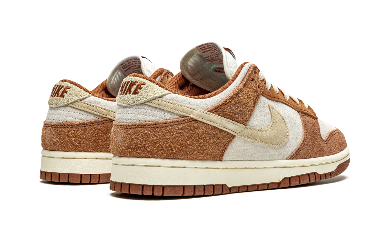 Nike Dunk Low PRM "Medium Curry" sneakers in oranje en bruin met witte details, zichtbaar op een schoenenfoto