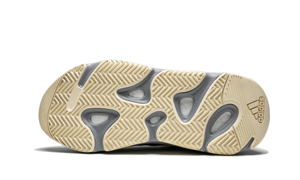 Lichte grijze Yeezy Boost 700 sneakers met wit en beige details, zichtbaar op een witte achtergrond.
