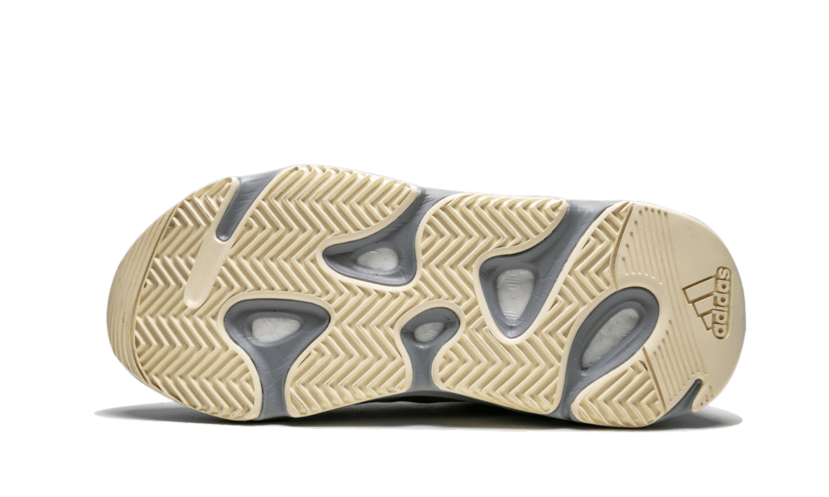 Lichte grijze Yeezy Boost 700 sneakers met wit en beige details, zichtbaar op een witte achtergrond.