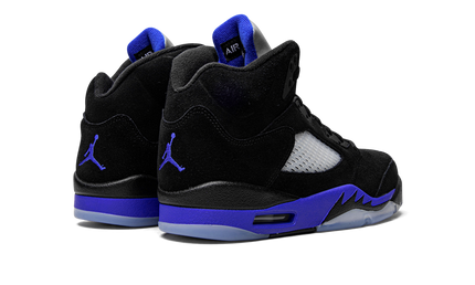 Witte en blauwe Air Jordan 5 Retro schoenen met zwarte details en oranje accenten, zichtbaar op de afbeelding.