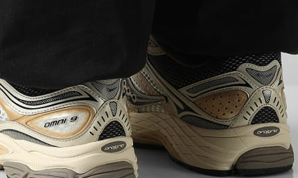 Gouden Saucony ProGrid Omni 9 sneakers van CAPE EXCLUSIVES met sportieve details en ademend mesh bovenwerk.