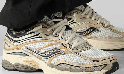 Sportieve Saucony ProGrid Omni 9 sneakers in goud, ontworpen door CAPE EXCLUSIVES, met een comfortabele en stijlvolle uitstraling