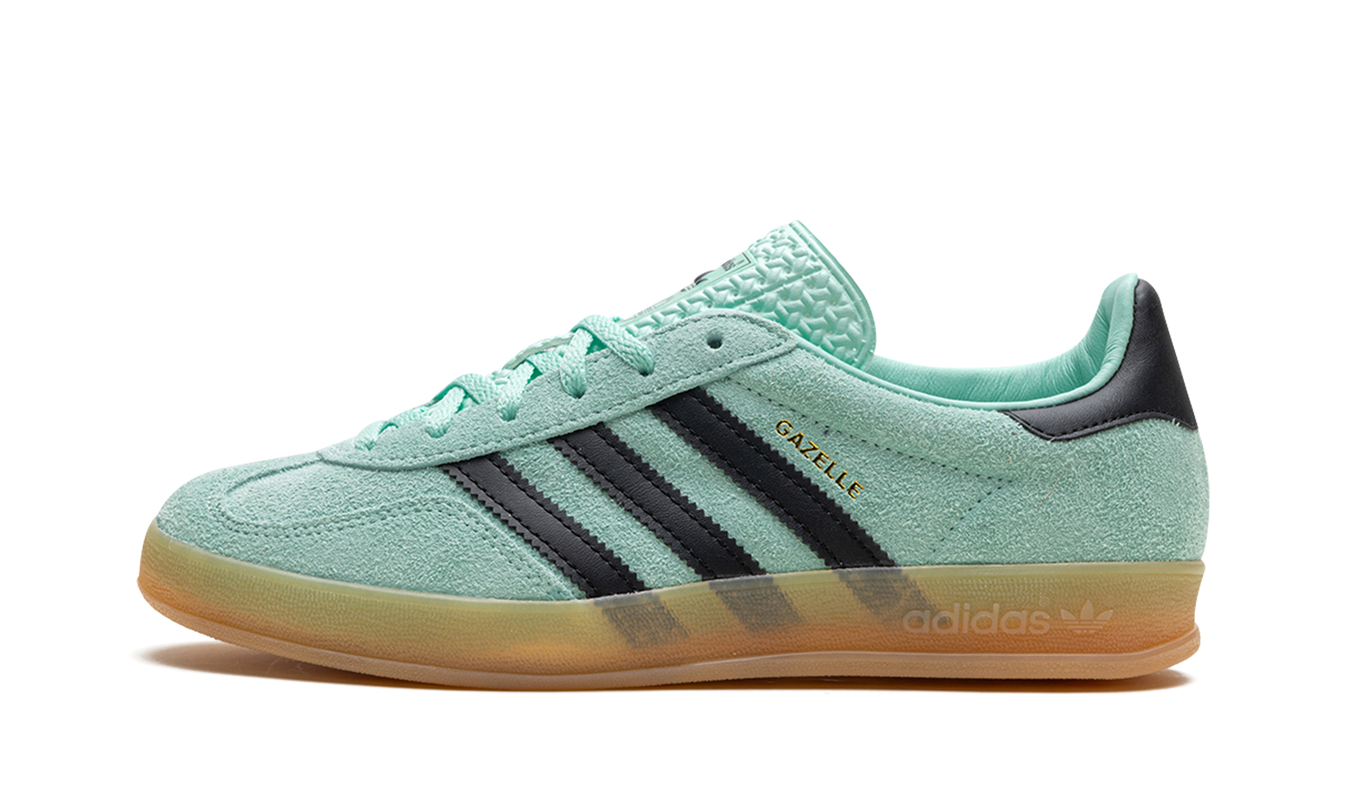 Sportieve Adidas Gazelle Indoor schoenen in zwart en crèmewit, met leren bovenwerk en witte zool.