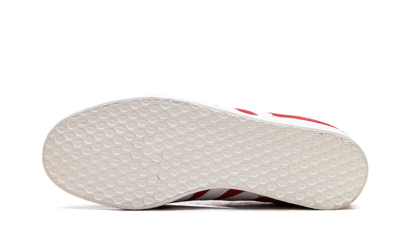 Adidas Gazelle schoenen in rood en wit, witte sneakers met rode accenten, zichtbaar op een witte achtergrond