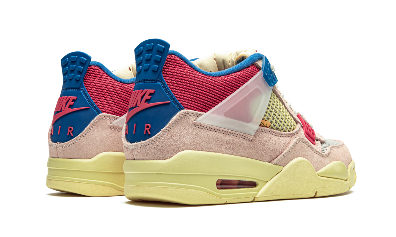 Witte Air Jordan 4 Retro SP "Union - Guava Ice" sneakers met oranje en blauwe accenten, zichtbaar in close-up afbeelding.