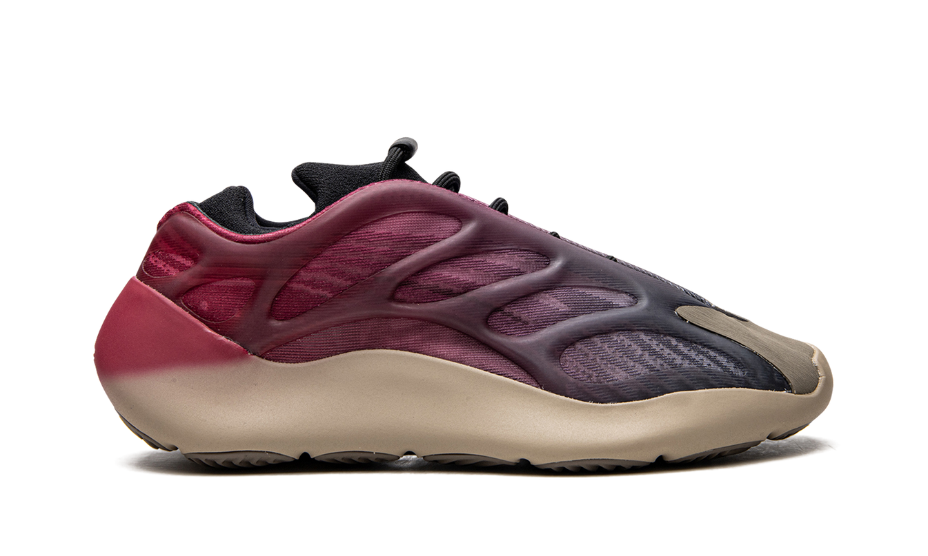 Zwarte Yeezy 700 V3 'Fade Carbon' sneakers met opvallend ontwerp en futuristische details, gedragen door een model.