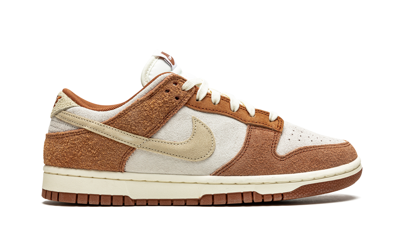 Nike Dunk Low PRM "Medium Curry" schoenen, close-up van de gele en bruine sneakers met detailrijke stof en veters.