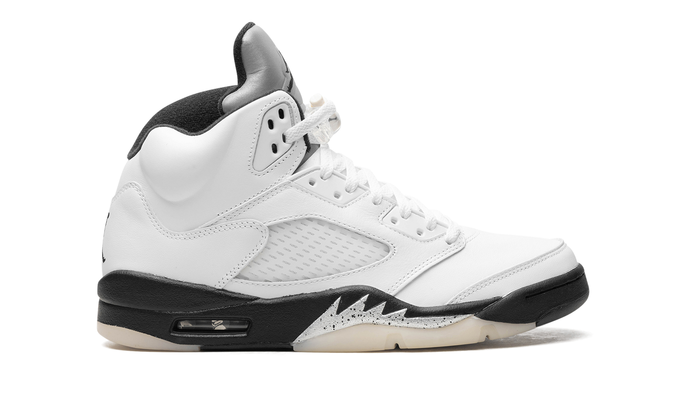 Witte en zwarte Air Jordan 5 schoenen met leren details en witte zool, gedragen door een model.