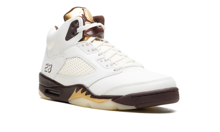 Lichte Air Jordan 5 WMNS "Golden Ticket" sneakers in goud en zwart, detailfoto van de schoenen met leren en mesh materialen.
