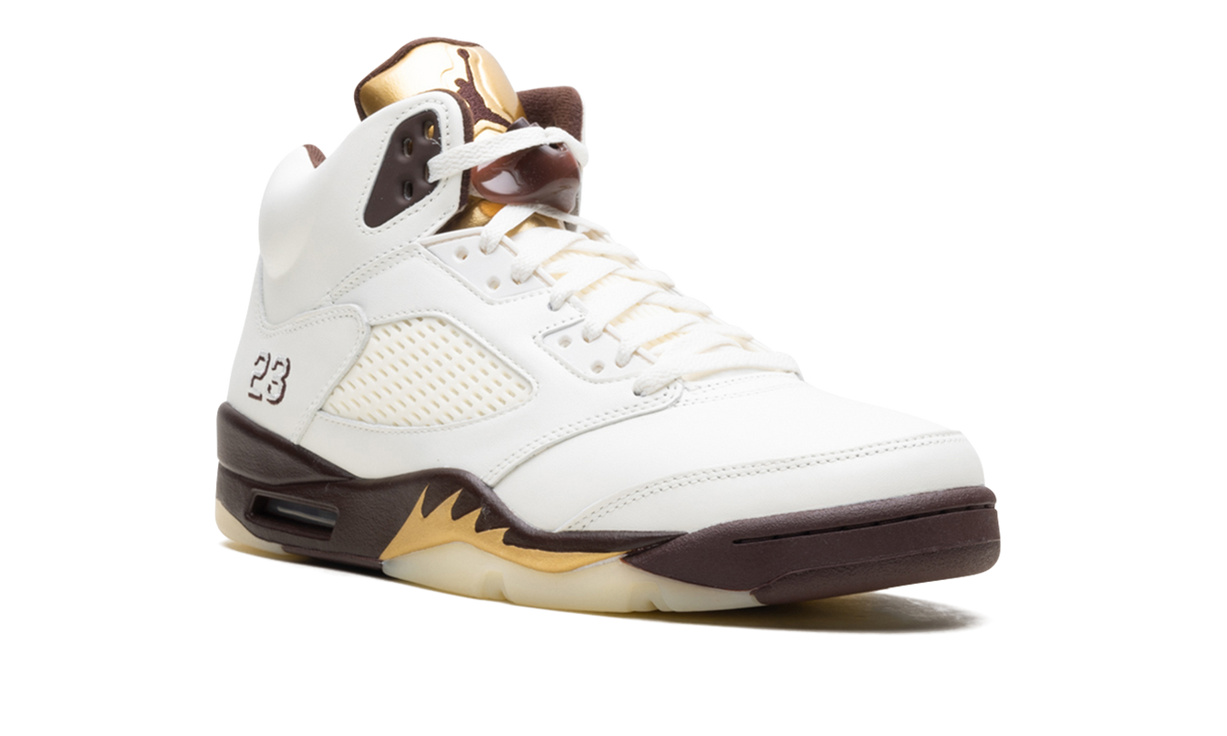 Lichte Air Jordan 5 WMNS "Golden Ticket" sneakers in goud en zwart, detailfoto van de schoenen met leren en mesh materialen.