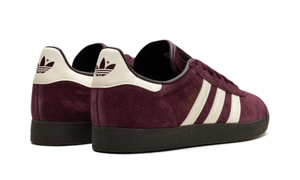 Lichte maroon Adidas Gazelle schoenen met witte zool en suède bovenkant, geschikt voor casual draagstijl.