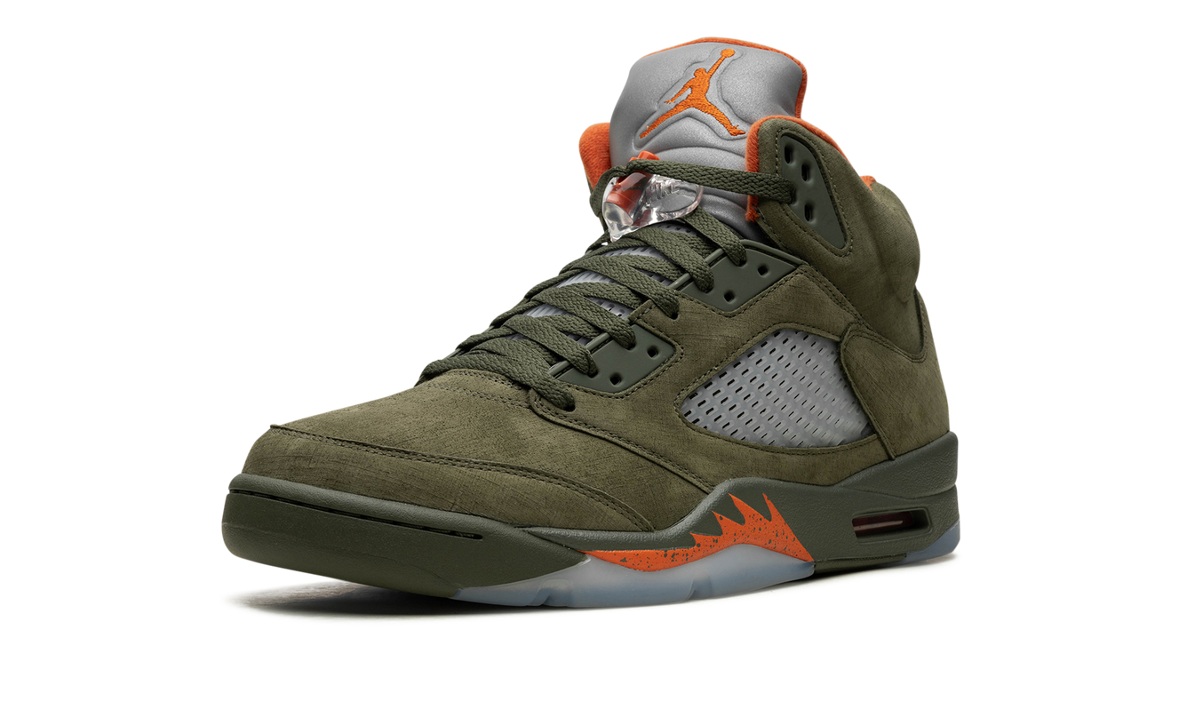 Lichte groene Air Jordan 5 OG sneakers van Mijn winkel met zwart en oranje details, zichtbaar in close-up.
