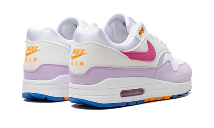 Nike Air Max 1 '87 WMNS schoenen met mismatched swoosh en kleurrijke details, zichtbaar in de afbeelding.