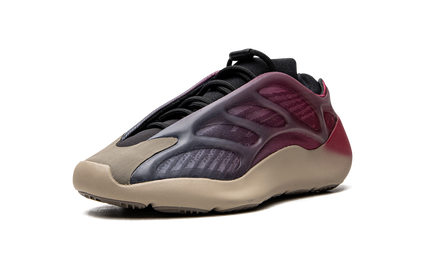 Zwarte en grijze Yeezy 700 V3 "Fade Carbon" sneakers met opvallend ontwerp en gebreide bovenkant, gedragen op een witte achtergrond.