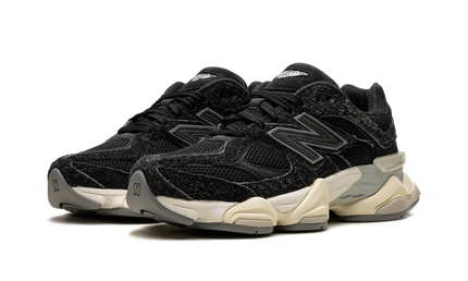 Zwarte suède New Balance 9060 schoenen met witte zool en sportieve uitstraling, geschikt voor casual en streetwear.