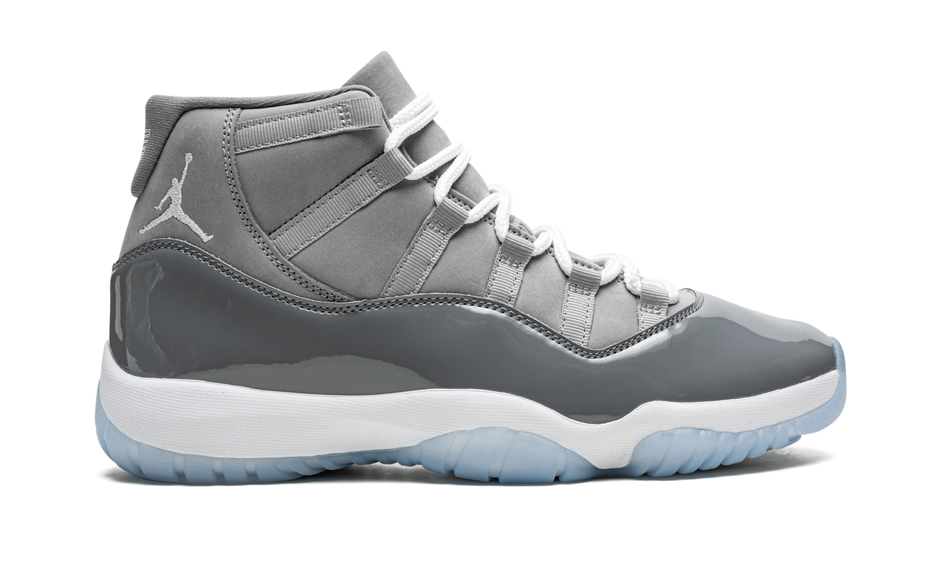 Lucht Jordan 11 Retro "Cool Grey 2021" schoenen met grijze leren bovenkant en witte zool, gedragen door een model.